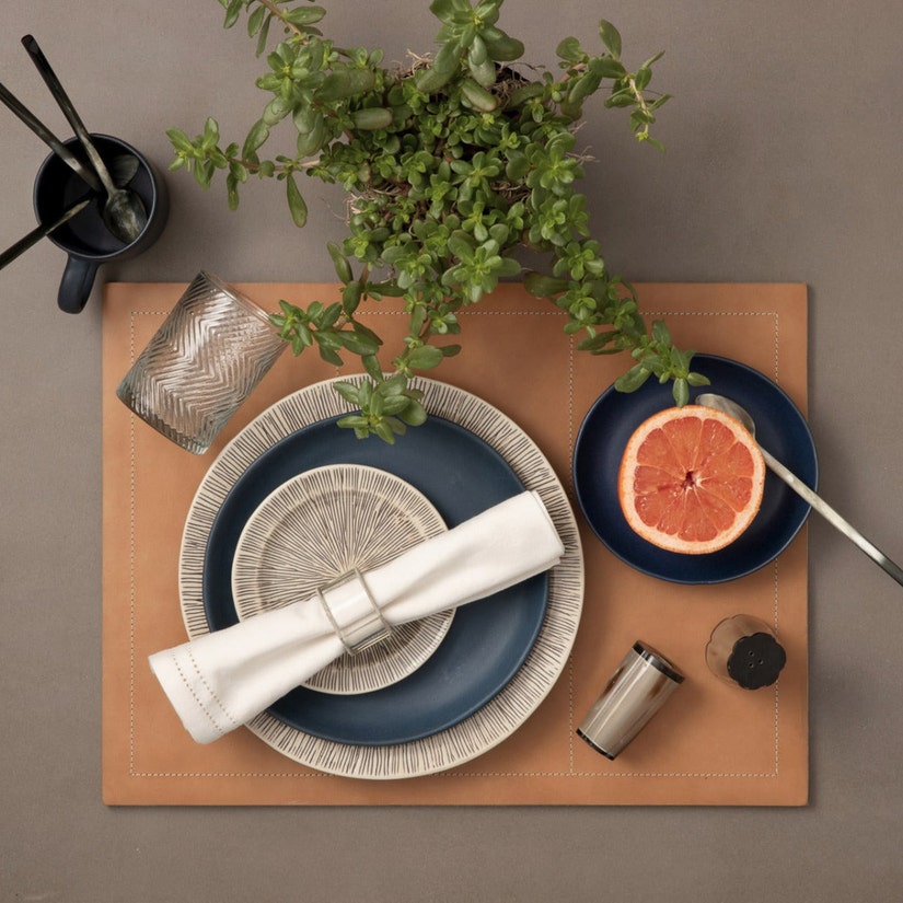 Blue Pheasant Nolan and Marcus, carefully curated and handmade dinnerware paired with leather placemat, white hemstitch dinner napkin all for a perfect tablescape from The Picket Fence
