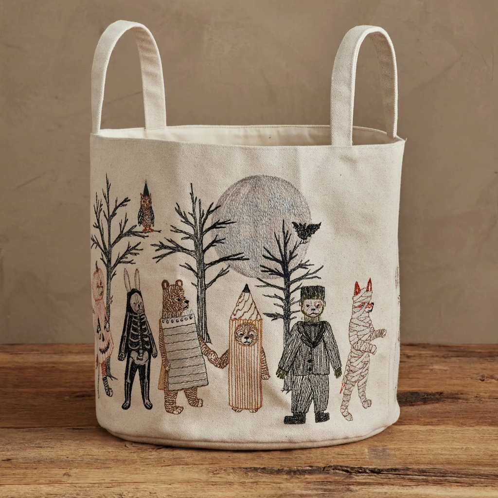 Coral & Tusk Full Moon Masquerade Halloween Bucket Canvas storage basket with animal and human illustrations on a wooden surface.